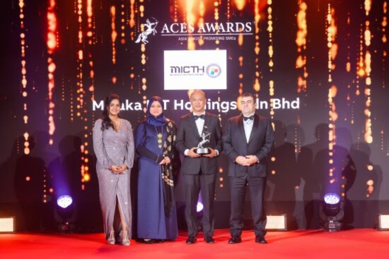 Dr. Nazdiana Ab Wahab, Chief Executive Officer of Melaka ICT Holdings Sdn Bhd (left center), and YB Datuk Fairul Nizam bin Roslan, Deputy Chairman of the Board of Directors (right center), proudly receive the Asia&#039;s Most Promising SMEs award on stage at the ACES Awards 2024. The award is presented by Dr. Shanggari Balakrishnan, President of the ACES Awards (far left), and Mr. Luis Bueno Nieto, Advisor to the ACES Council (far right), in recognition of the Melaka ICT Holdings Sdn Bhd&#039;s exceptional growth and promising future in the industry.